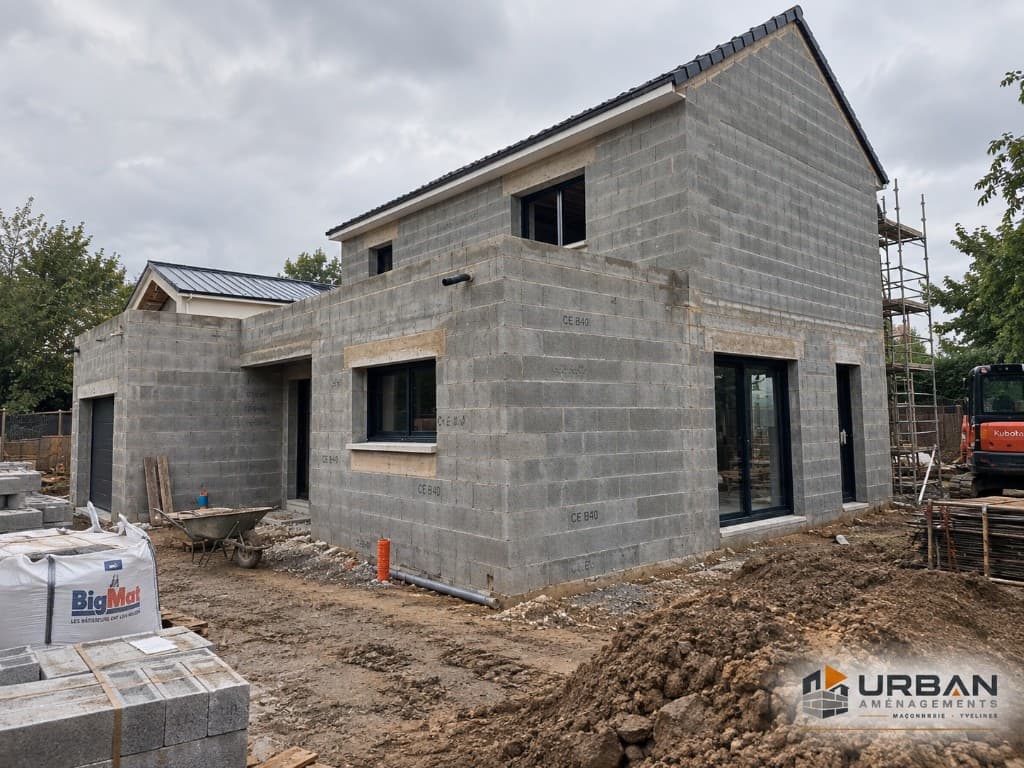 Chantier de maçonnerie Urban Aménagements dans les Yvelines — élévation en blocs béton, baies posées et engins de terrassement